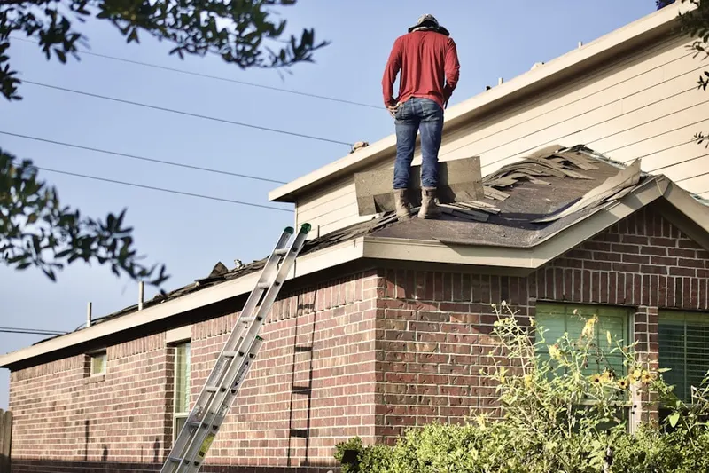 Professional roofer working on a residential roof in Eidson Road
